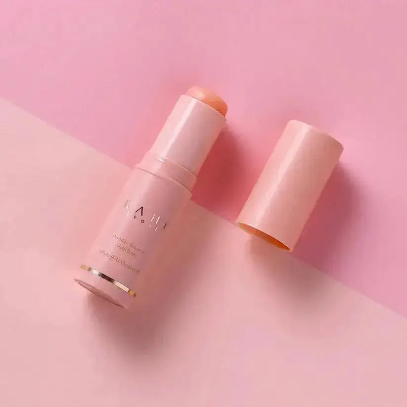 KAHI Wrinkle Bounce Multi Balm 9g on a pink background with cap off, showcasing the anti-aging moisturizer.